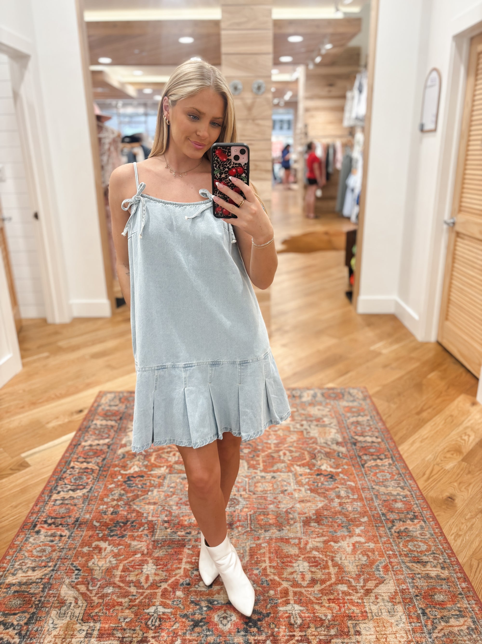 Expertly crafted with light washed denim, this mini dress features a charming bow and pleats detail. Made from a soft and breathable blend of 90% cotton and 10% polyester, it boasts a square neckline and sleeveless design for a flattering and comfortable fit. Elevate your wardrobe with this versatile and stylish piece. Boutique style Ashland, Kentucky 