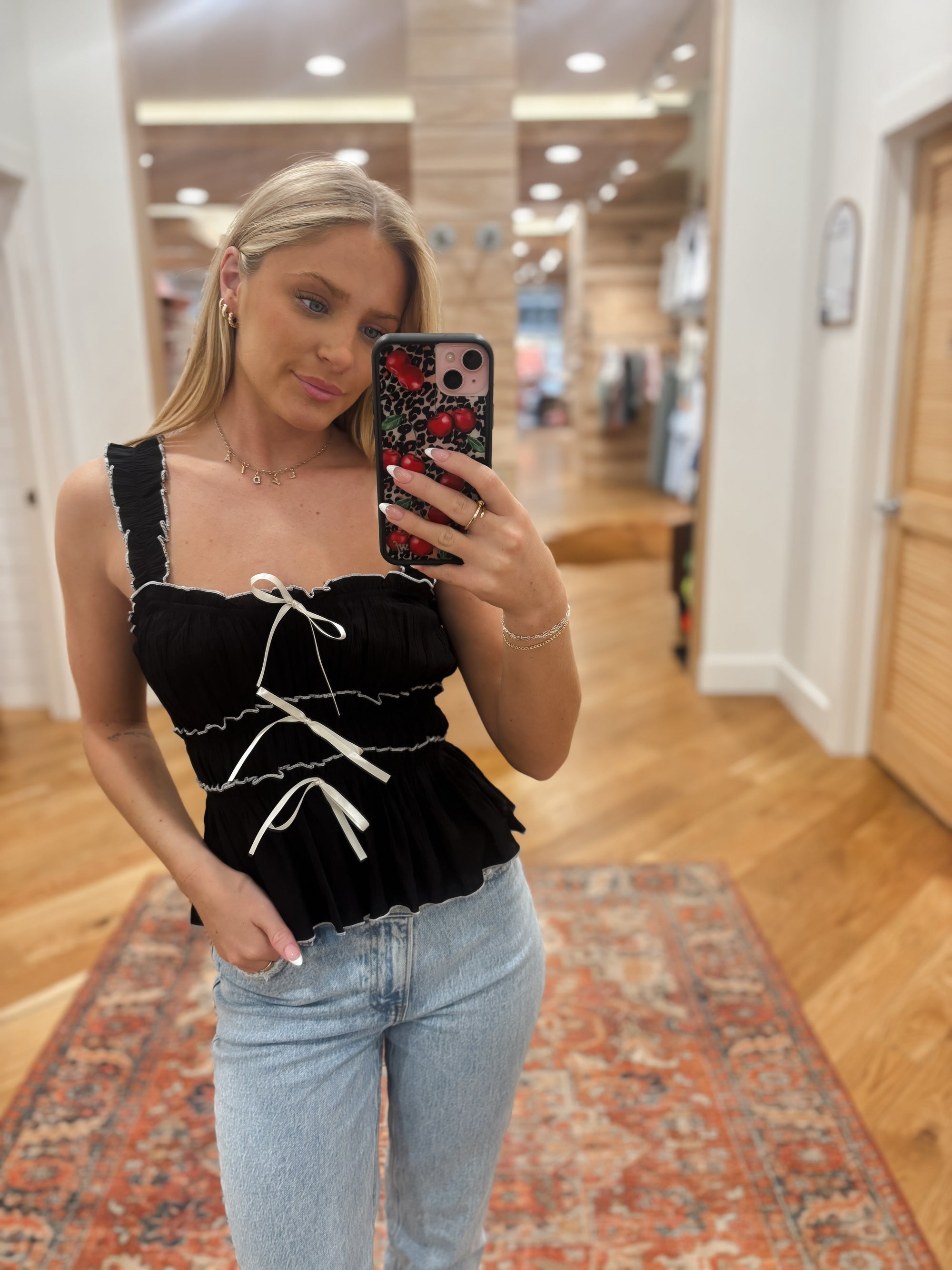 Expertly crafted from lightweight, slightly sheer woven material, the Azura Black Top offers a chic yet comfortable addition to any wardrobe. With a square neckline and wide ruched elastic straps, this top also features a front bow detail and contrast detailing for a unique touch. Boutique style Ashland, Kentucky 