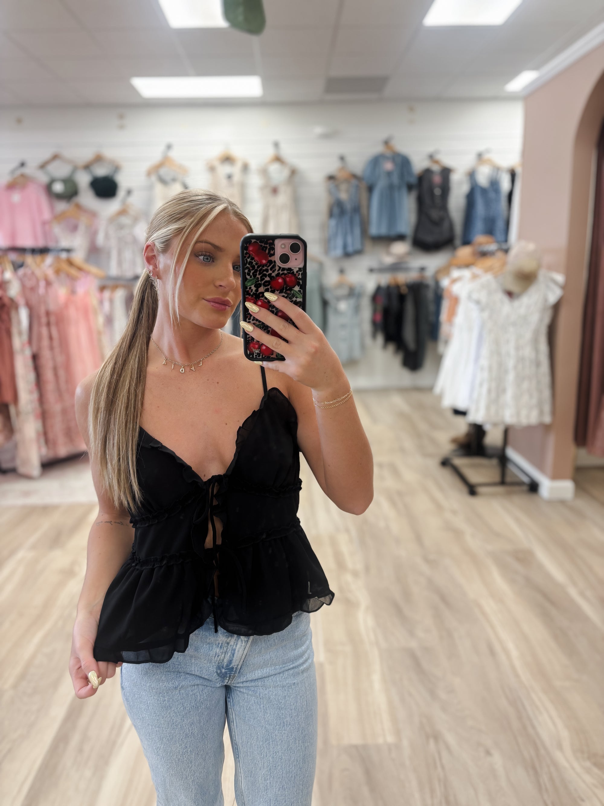 Add a touch of elegance to your outfit with ourChiffon Sleeveless Cami Black Topi. The flattering V-neck and delicate spaghetti straps provide a feminine touch, while the ruffle detail and front tie closure add a sophisticated flair. Made with 100% polyester for both style and comfort. Boutique style Ashland, Kentucky 