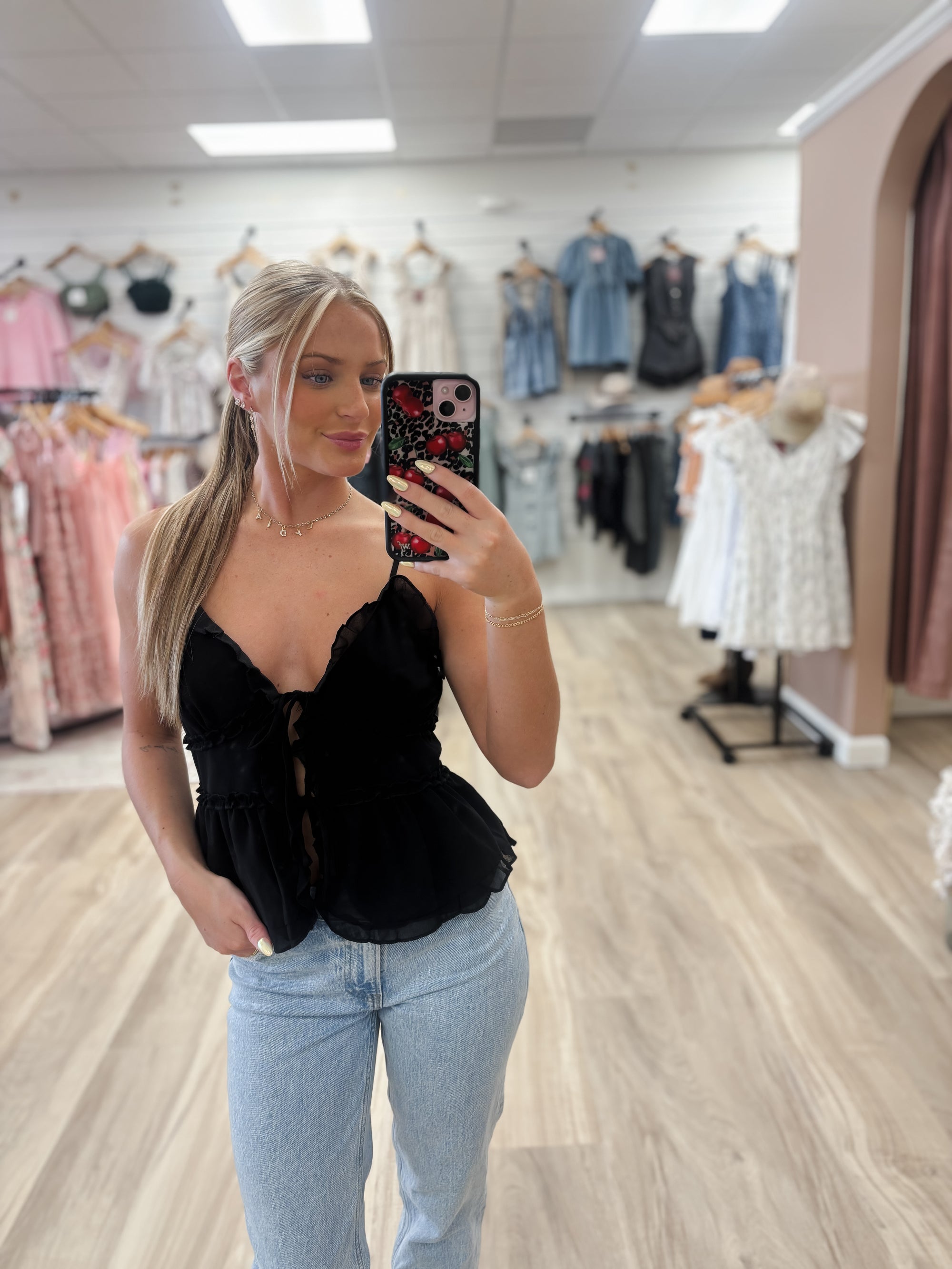 Add a touch of elegance to your outfit with ourChiffon Sleeveless Cami Black Topi. The flattering V-neck and delicate spaghetti straps provide a feminine touch, while the ruffle detail and front tie closure add a sophisticated flair. Made with 100% polyester for both style and comfort. Boutique style Ashland, Kentucky 