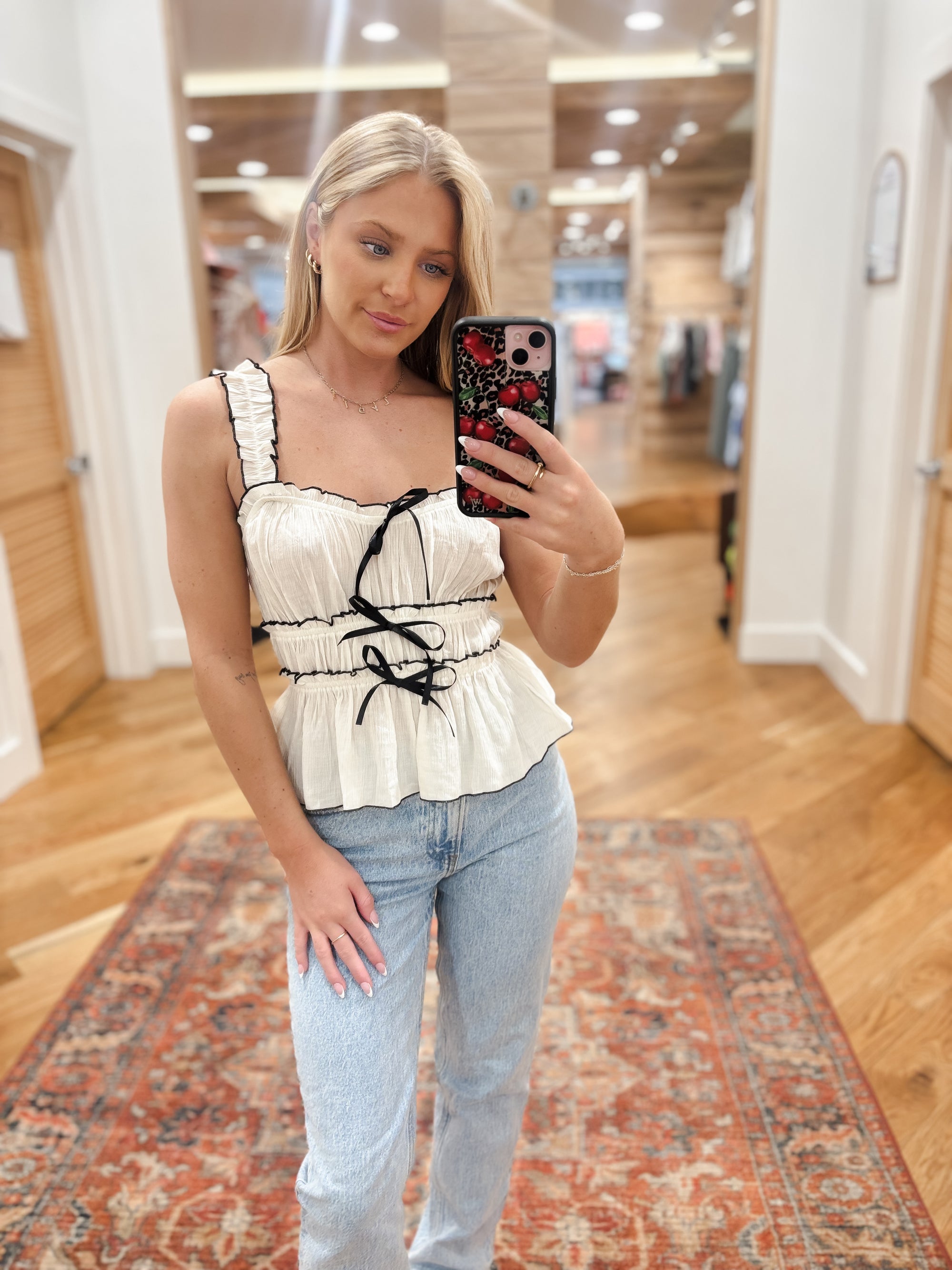 Expertly crafted from lightweight, slightly sheer woven material, the Azura Ivory Top offers a chic yet comfortable addition to any wardrobe. With a square neckline and wide ruched elastic straps, this top also features a front bow detail and contrast detailing for a unique touch. Boutique style Ashland, Kentucky  