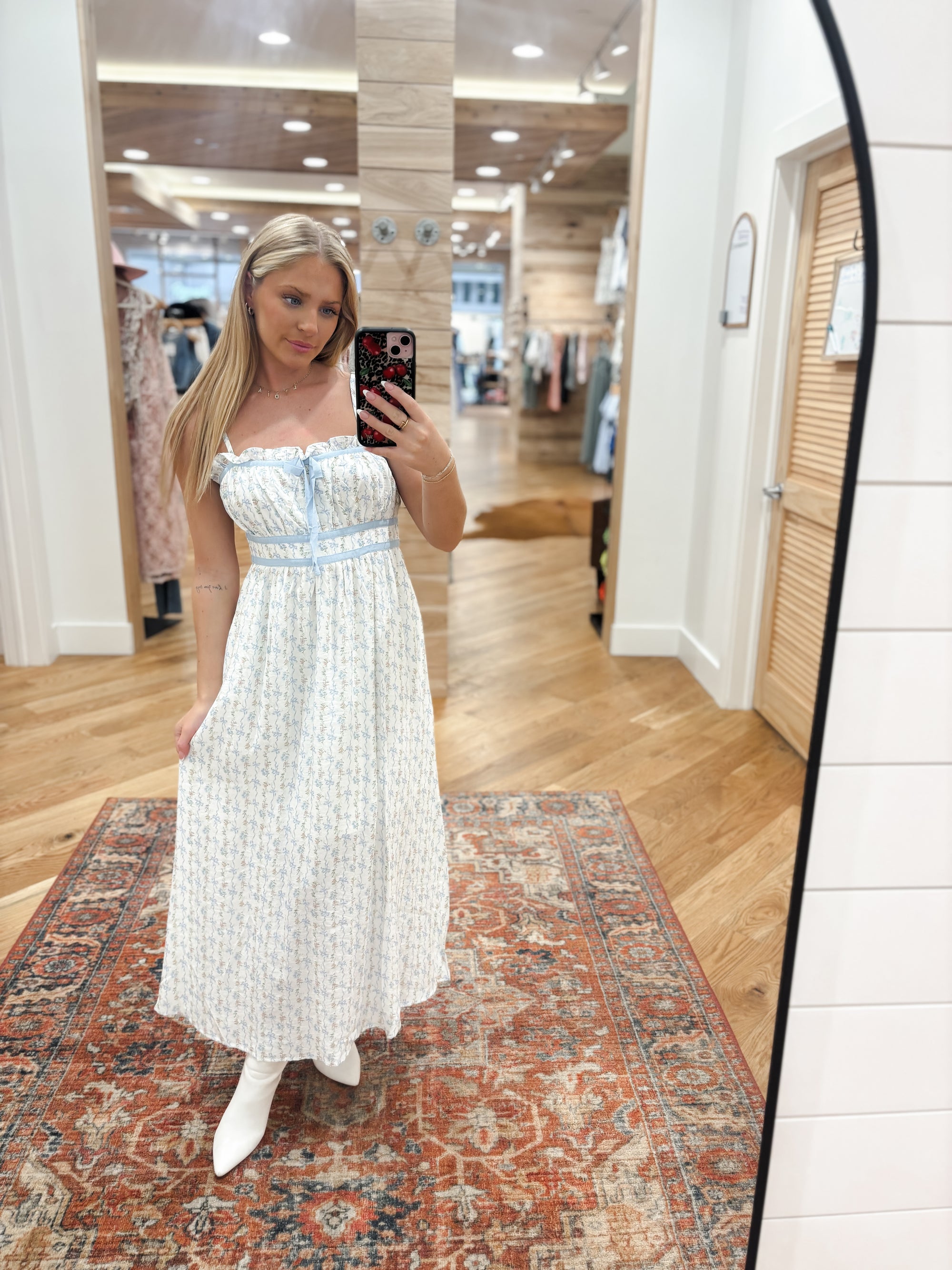 Effortlessly elevate your style with our Calla Blue Midi Dress. Featuring a charming floral bow pattern and ruffle trim, this dress is designed with a square neckline, adjustable spaghetti straps, and an elastic back waist tunnel for a flattering fit. The contrast front tie detail adds a touch of elegance. Boutique style Ashland, Kentucky 